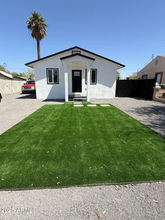 a view of a white house with a yard