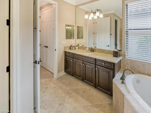 a spacious bathroom with a granite countertop sink and a mirror