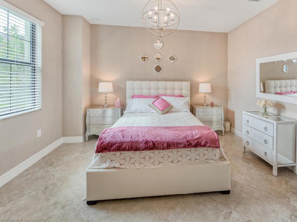 9491 Piacere Way Naples, FL 34113 - Photo 16 of 34 a bedroom with a bed chandelier and window