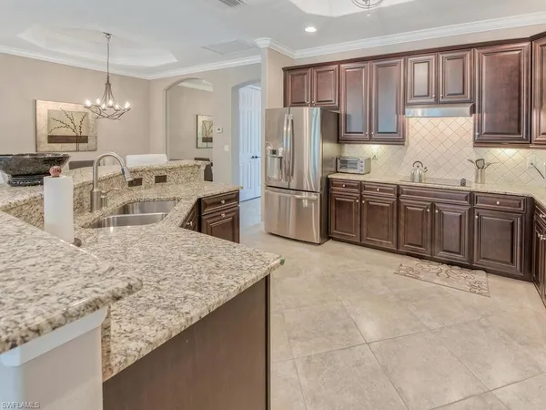 a kitchen with stainless steel appliances granite countertop a sink refrigerator and cabinets
