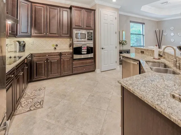 a kitchen with stainless steel appliances granite countertop a stove a sink and a microwave
