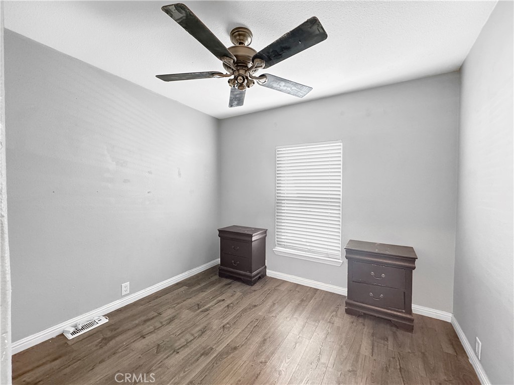 220 South Elk, Unit 75 Hemet, CA 92543 - Photo 11 of 14 an empty room with wooden floor fan and windows