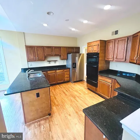 a kitchen with stainless steel appliances granite countertop a sink and a refrigerator