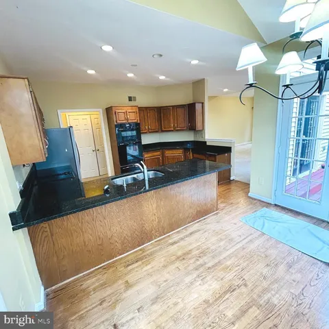 a view of kitchen with stainless steel appliances granite countertop sink stove and refrigerator