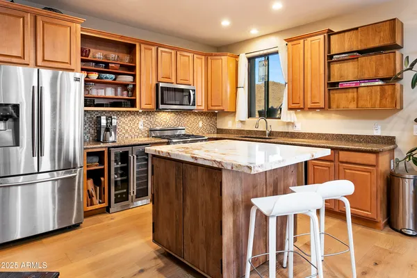 a kitchen with stainless steel appliances granite countertop a refrigerator and wooden cabinets