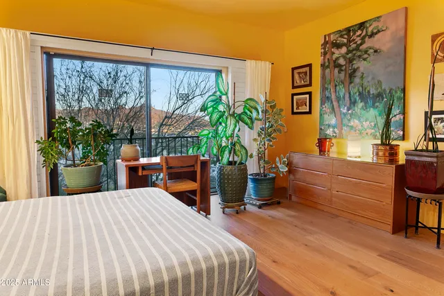 a bedroom with a large bed and a potted plant