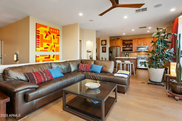 a living room with furniture kitchen view and a large window