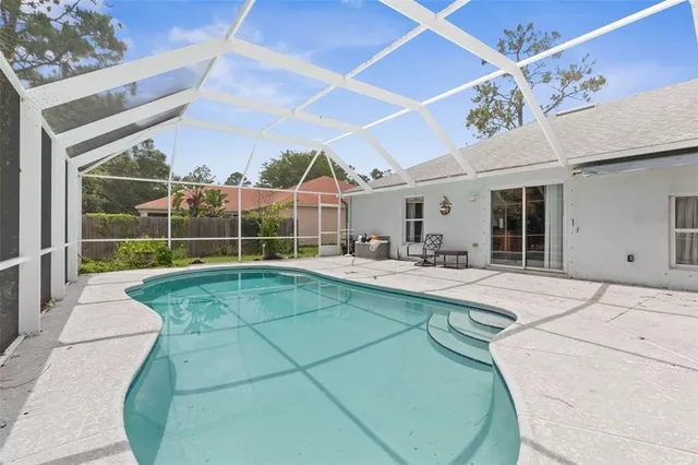 a swimming pool with outdoor seating and yard