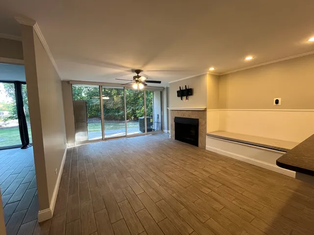 a view of empty room with wooden floor and fireplace
