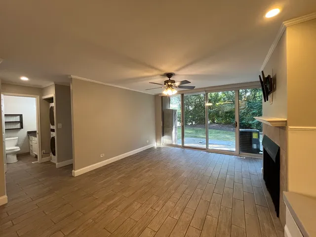 a view of empty room with wooden floor and fireplace
