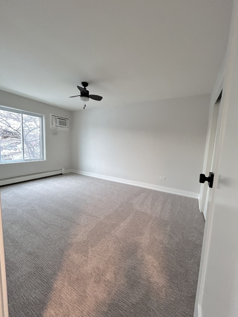 239 North Gregory Street, Unit 8 Aurora, IL 60504 - Photo 5 of 15 wooden floor in an empty room with a window