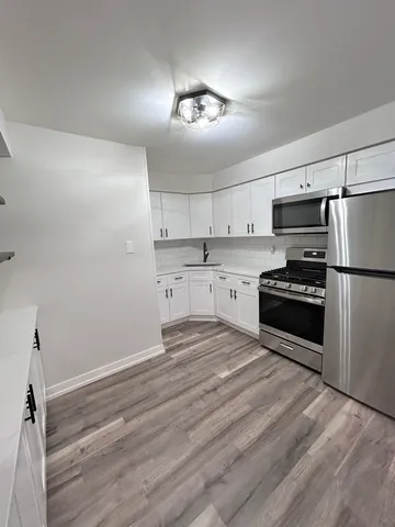 a kitchen with granite countertop a refrigerator and a stove top oven