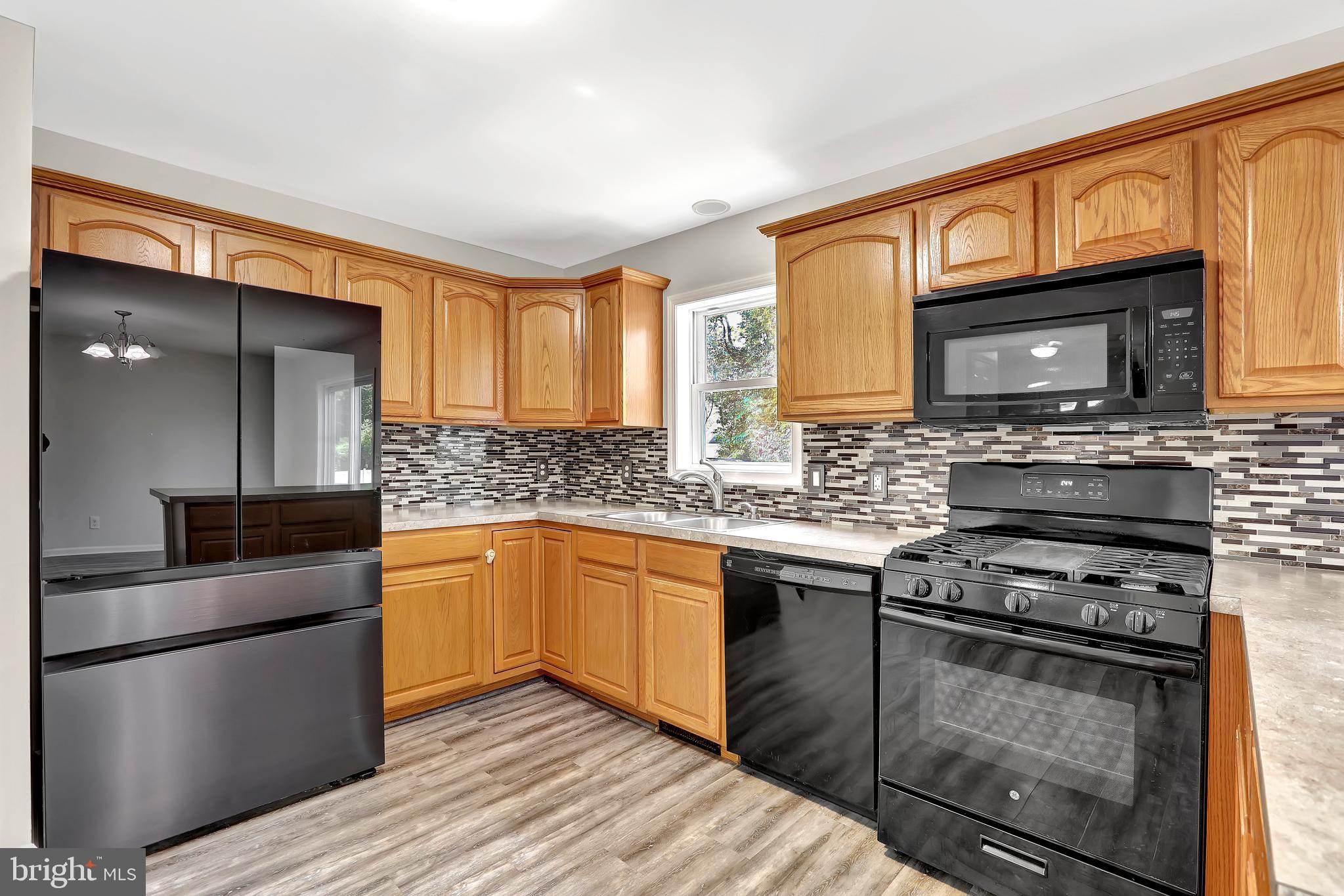 515 Ridge Avenue Hamilton, NJ 08610 - Photo 7 of 30 a kitchen with stainless steel appliances granite countertop a stove microwave and sink
