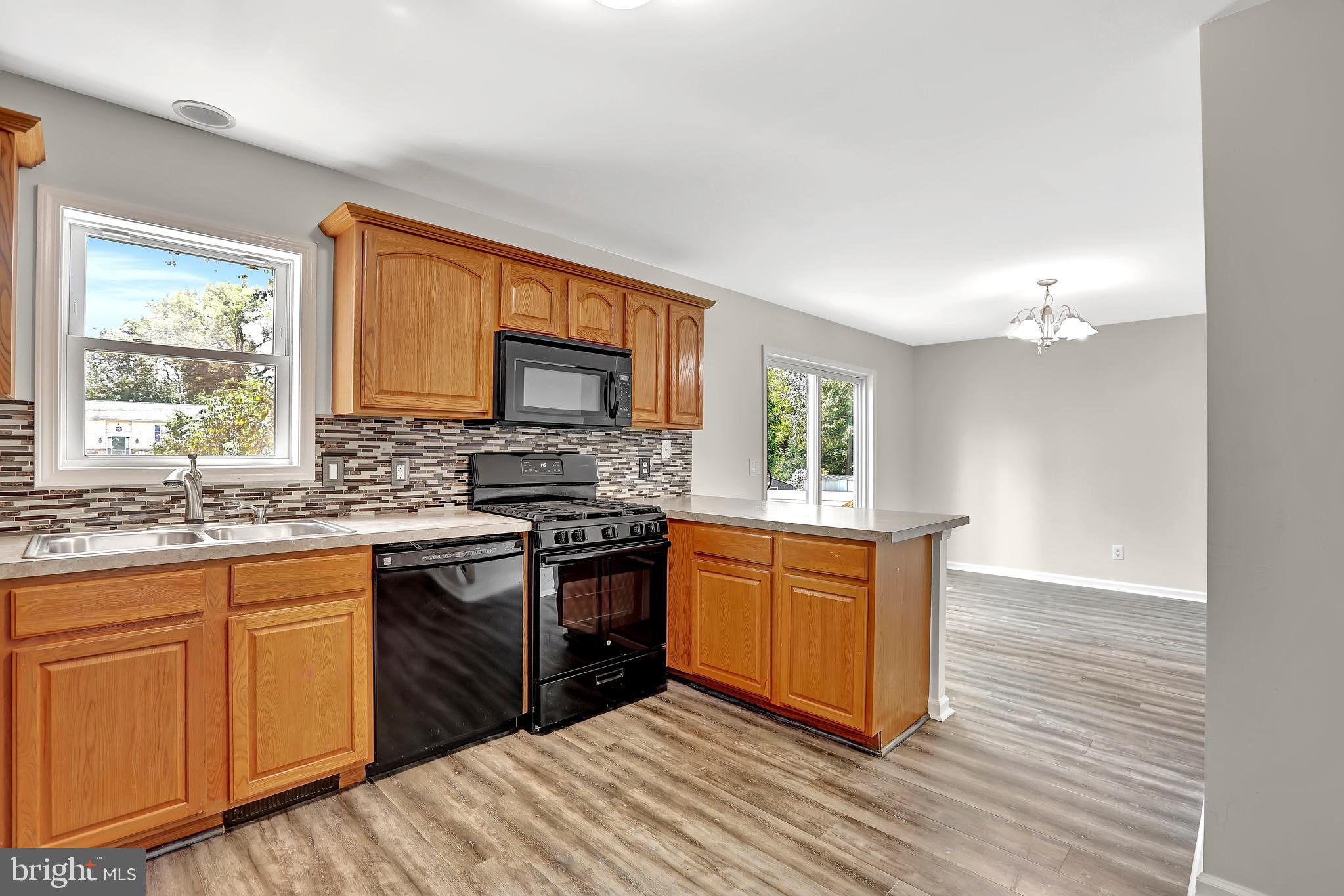 515 Ridge Avenue Hamilton, NJ 08610 - Photo 9 of 30 a kitchen with stainless steel appliances granite countertop a stove a sink dishwasher and a refrigerator with wooden floor