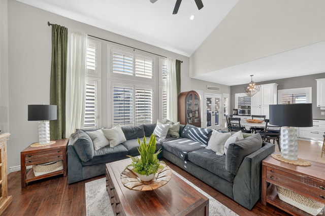 14738 Tangle Hill Road Herriman, UT 84096 - Photo 25 of 66 Open-concept living area with vaulted ceilings, large windows featuring plantation shutters, and wood-finish flooring