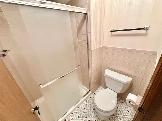 a white toilet sitting next to a shower curtain