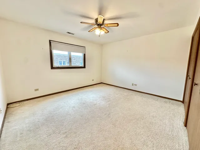 an empty room with a ceiling fan and a window