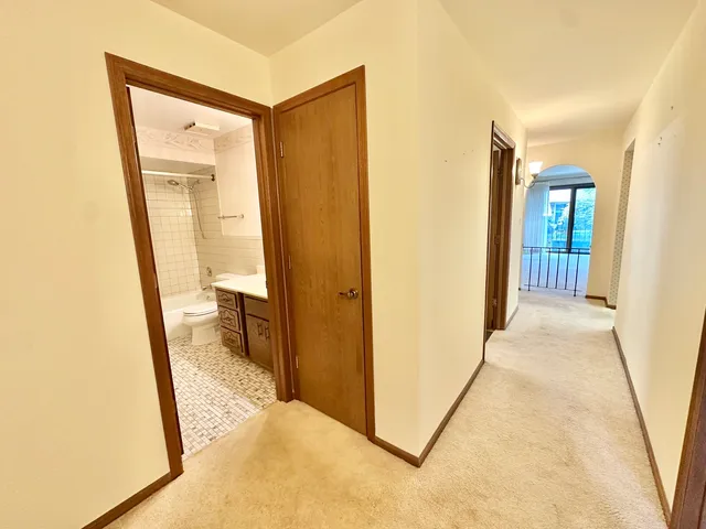 a view of a hallway with wooden floor and a livingroom