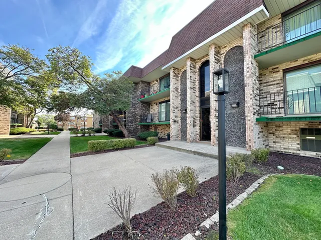 a front view of a house with a yard and potted plants