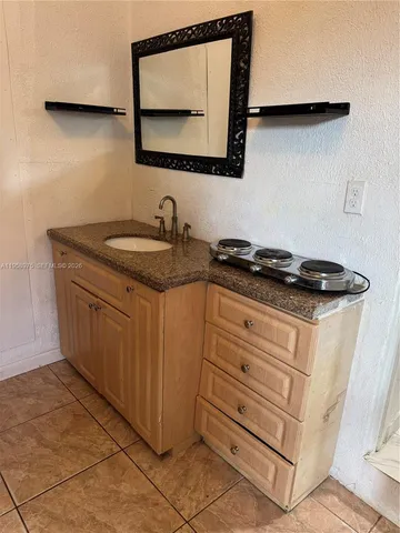 a kitchen with granite countertop a sink and a stove
