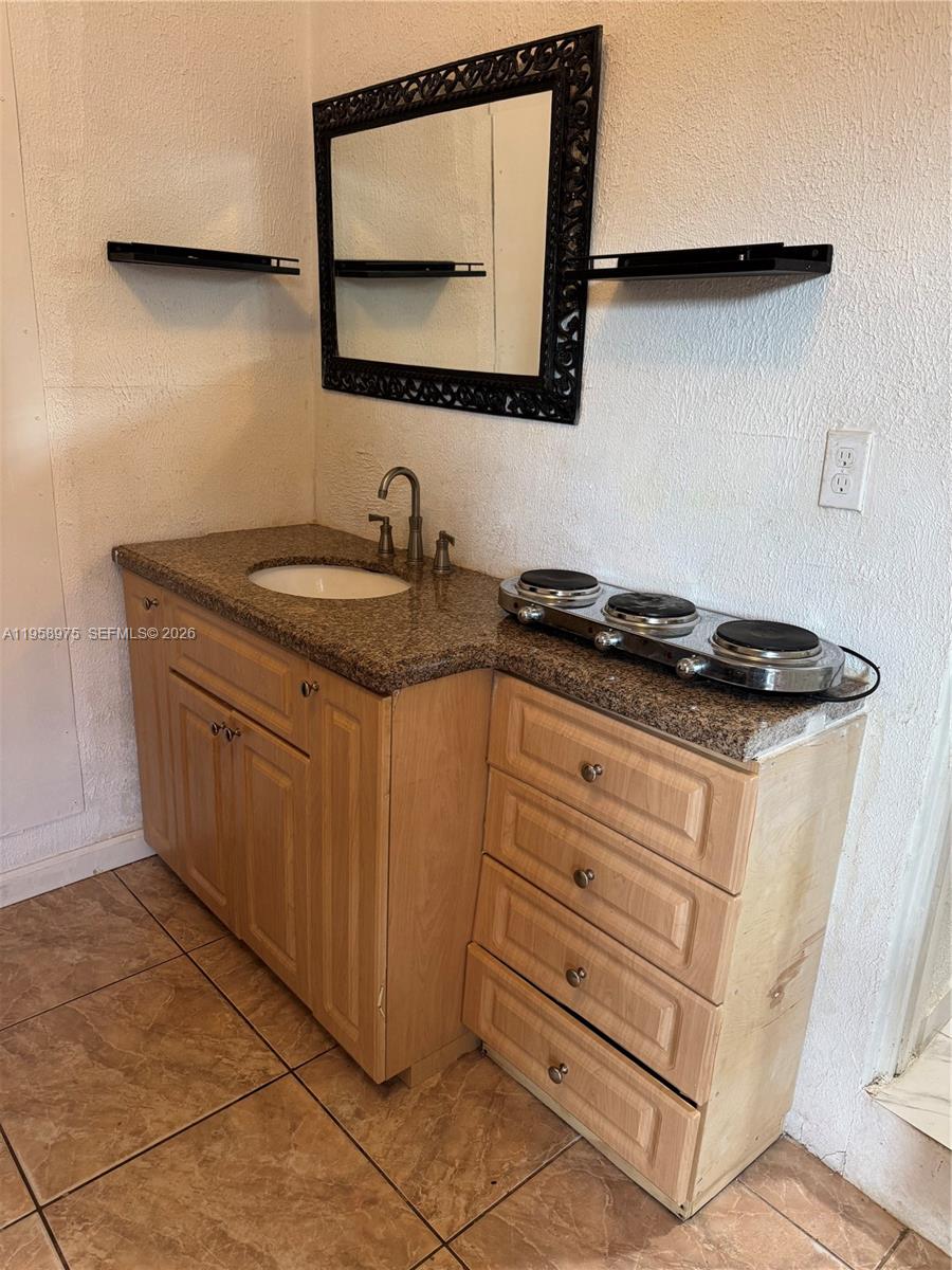 1822 Cleveland Street, Unit 3 Hollywood, FL 33020 - Photo 31 of 35 a bathroom with a granite countertop sink and a mirror