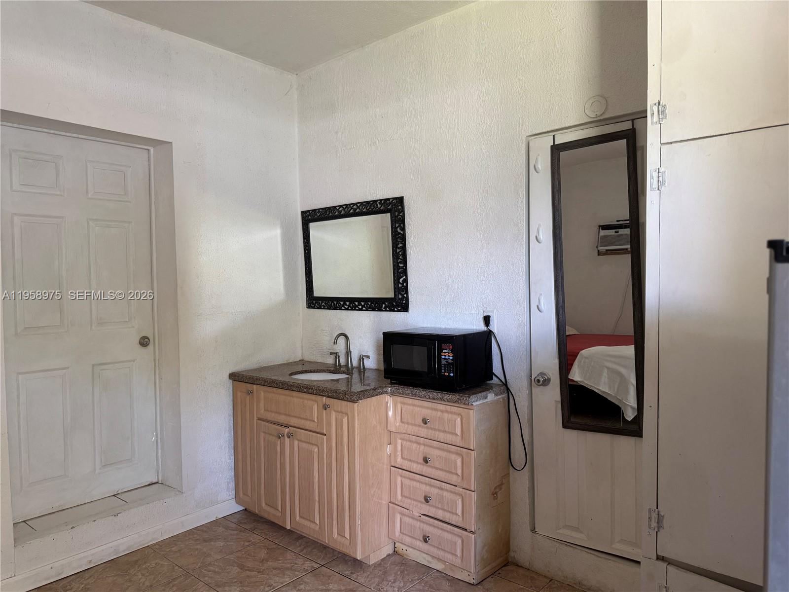 1822 Cleveland Street, Unit 3 Hollywood, FL 33020 - Photo 5 of 35 a bedroom with a bed and a mirror