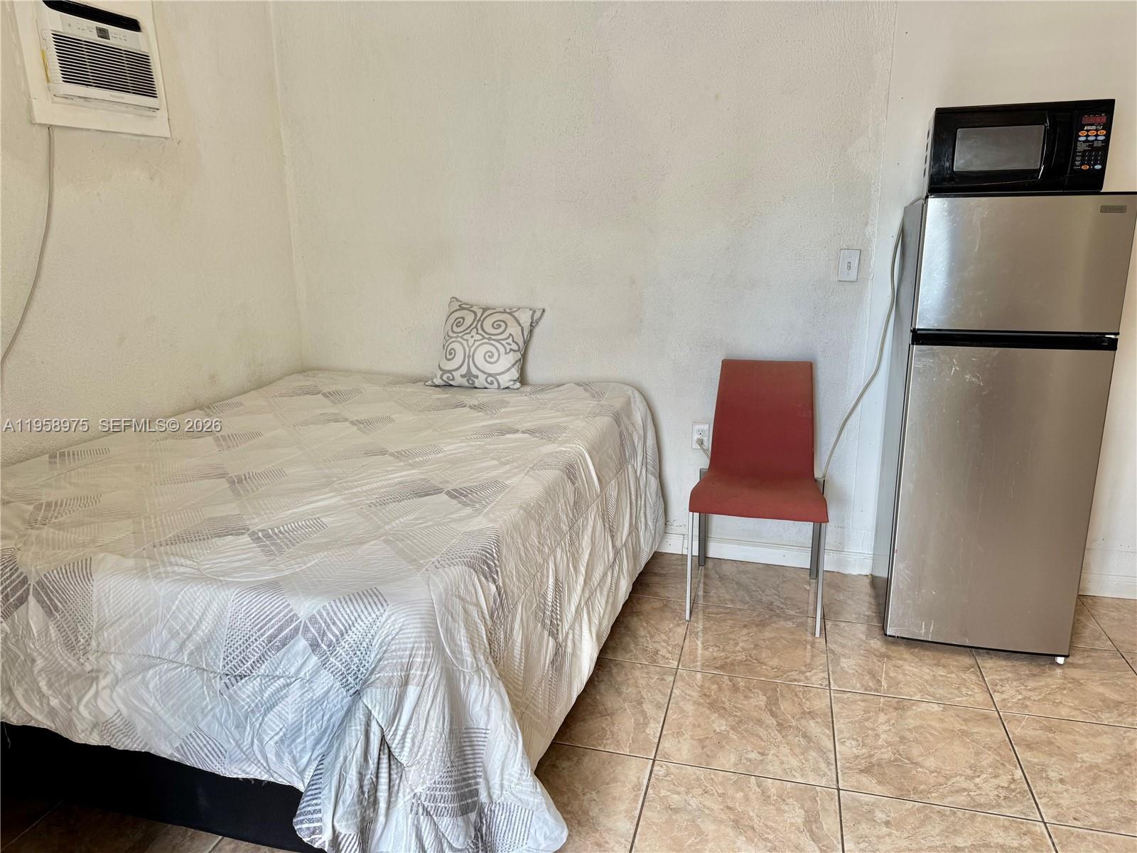 1822 Cleveland Street, Unit 3 Hollywood, FL 33020 - Photo 6 of 35 a bed sitting in a bedroom next to a chair