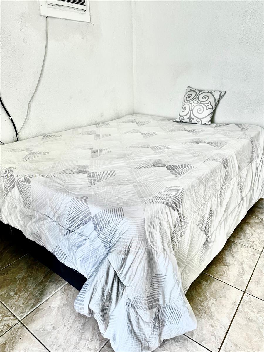 1822 Cleveland Street, Unit 3 Hollywood, FL 33020 - Photo 7 of 35 a bedroom with a bed and a night stand