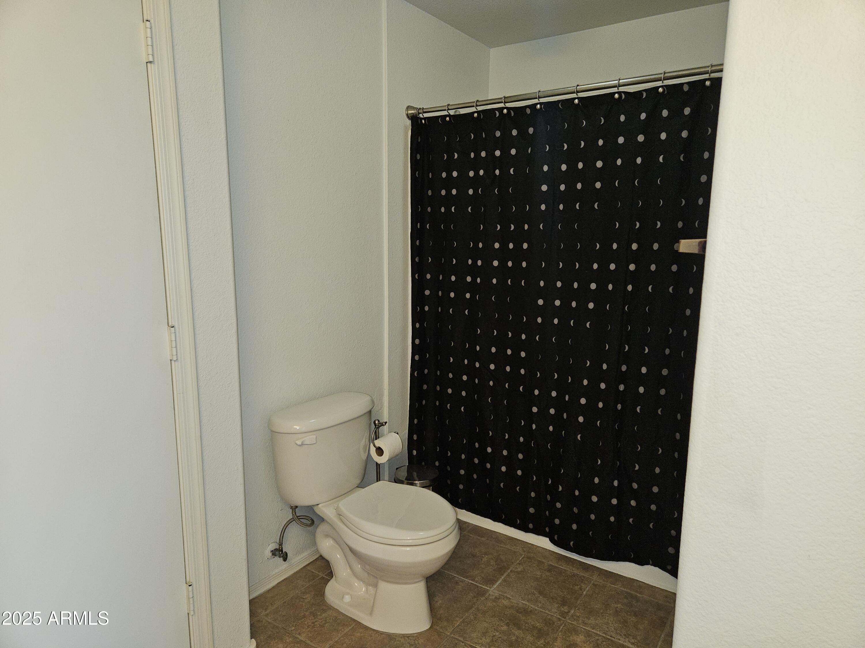 3302 North 7th Street, Unit 332 Phoenix, AZ 85014 - Photo 21 of 33 a bathroom with a toilet and a shower curtain