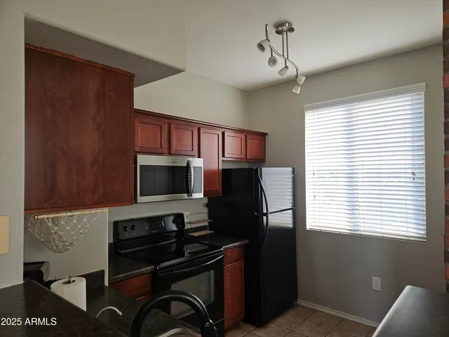 a kitchen with stainless steel appliances granite countertop a sink stove and microwave