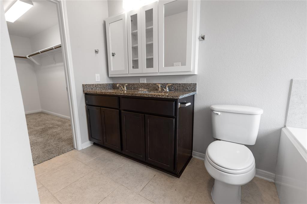 3933 Rimfire Road Waco, TX 76705 - Photo 20 of 27 a bathroom with a toilet a sink and a mirror
