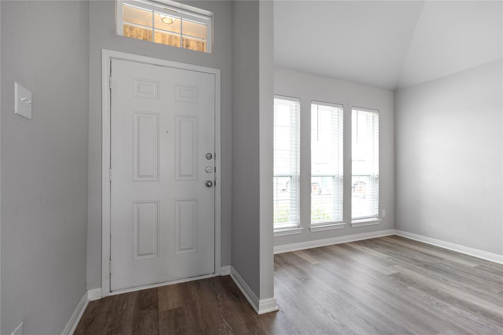 3933 Rimfire Road Waco, TX 76705 - Photo 3 of 27 an empty room with wooden floor and windows