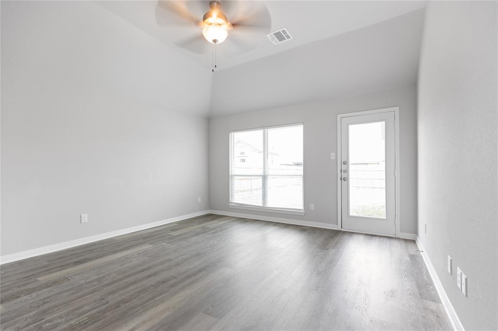 3933 Rimfire Road Waco, TX 76705 - Photo 6 of 27 an empty room with wooden floor and windows
