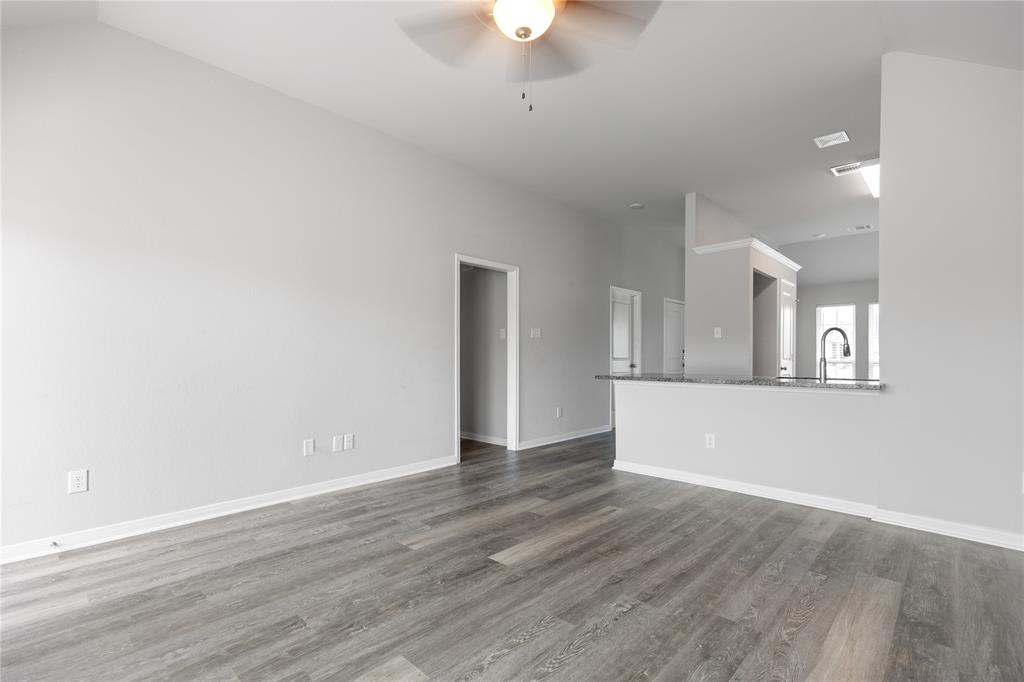 3933 Rimfire Road Waco, TX 76705 - Photo 7 of 27 a view of an empty room with window and wooden floor