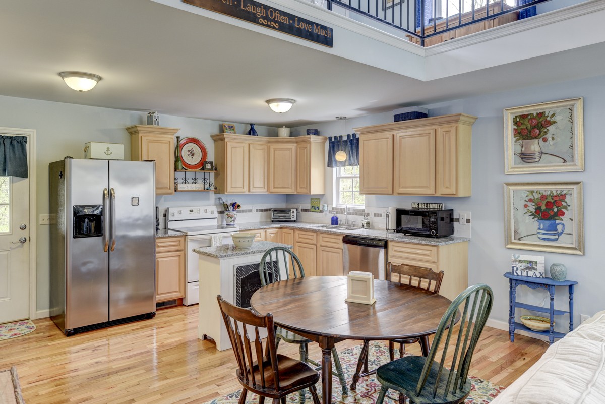 8565 South Tatum Creek Road Lyles, TN 37098 - Photo 29 of 31 a kitchen with stainless steel appliances granite countertop a refrigerator a stove a sink a dining table and chairs with wooden floor