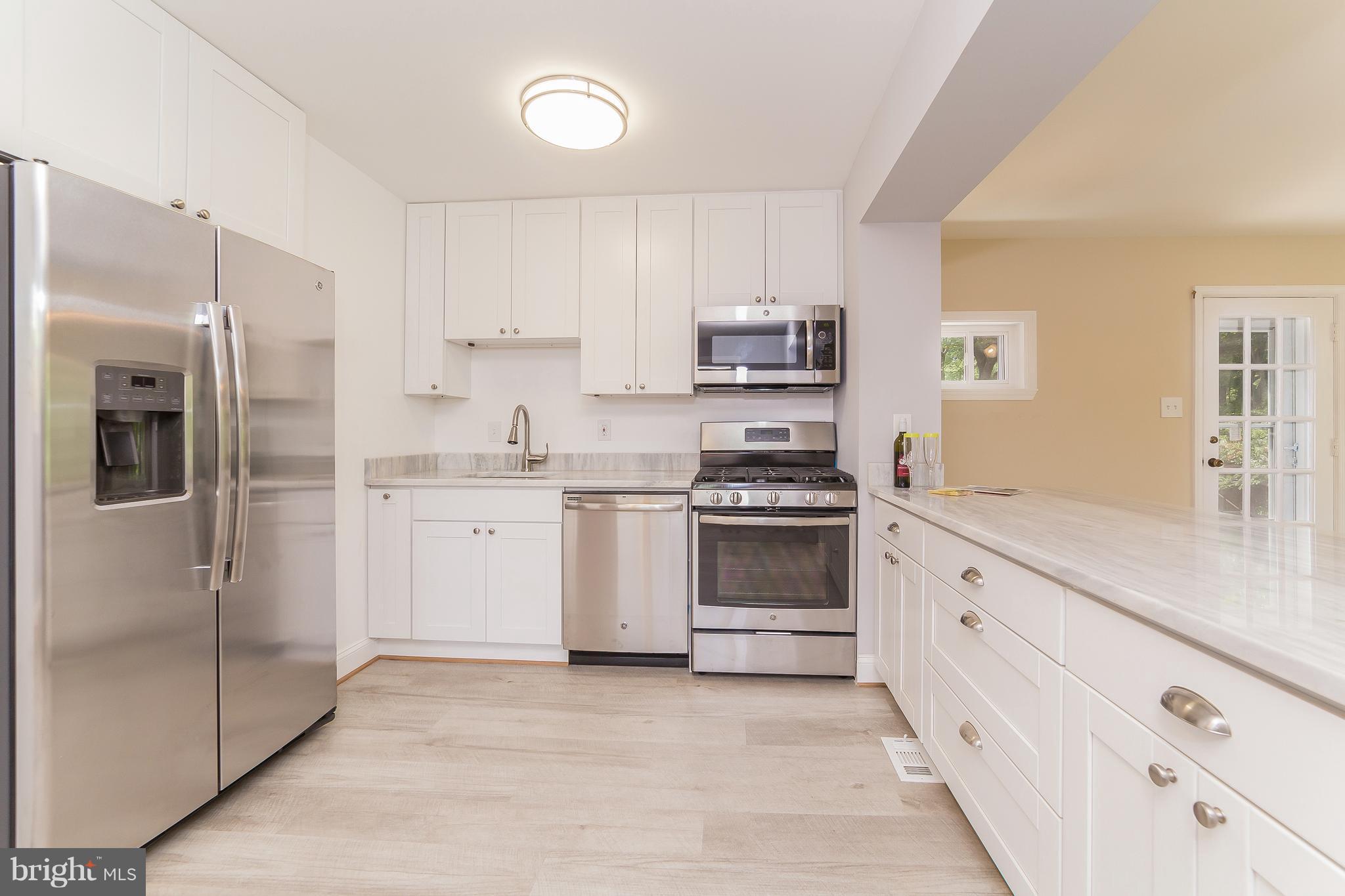 917 Benson Terrace Silver Spring, MD 20901 - Photo 5 of 25 a kitchen with stainless steel appliances a refrigerator sink and cabinets