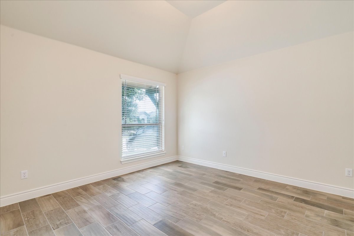 124 Compass Lane Kyle, TX 78640 - Photo 26 of 38 an empty room with wooden floor and window