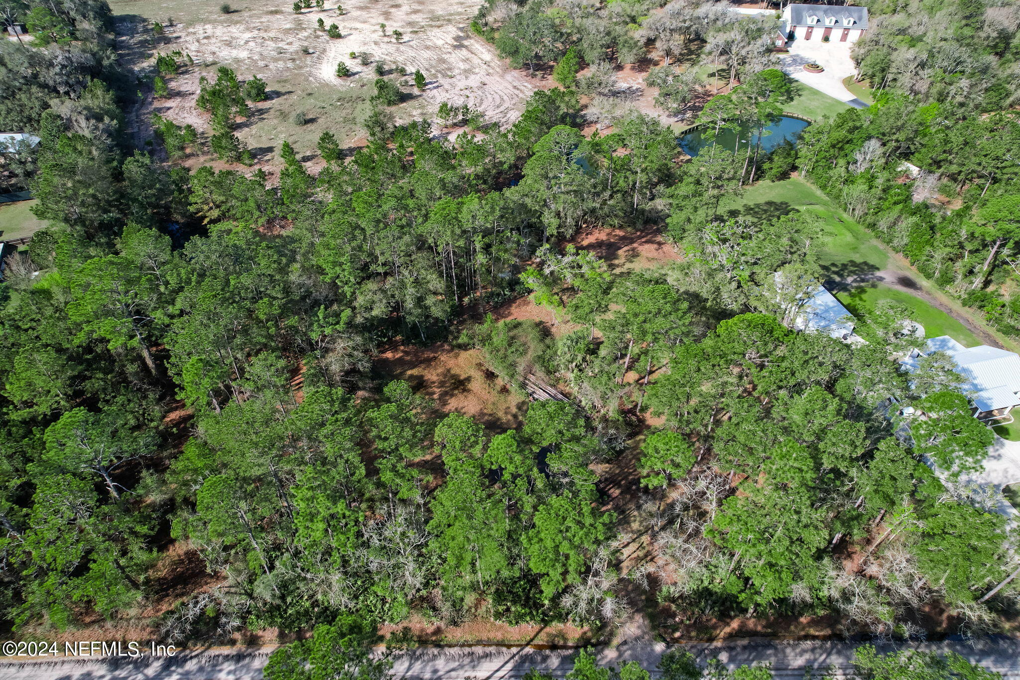 87273 Raddin Road Yulee, FL 32097 - Photo 9 of 14 an aerial view of residential house with outdoor space and trees all around