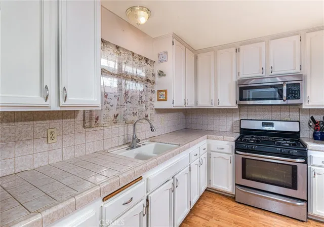 a kitchen with appliances a sink and cabinets