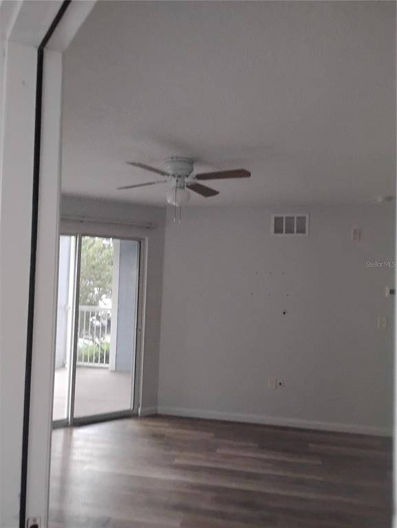 2549 Grassy Point Drive, Unit 203 Lake Mary, FL 32746 - Photo 3 of 22 a view of an empty room with wooden floor and a window