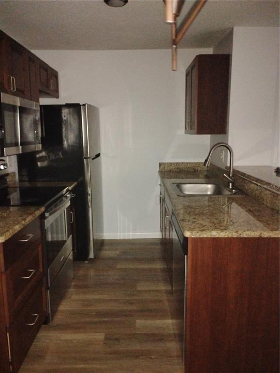 2549 Grassy Point Drive, Unit 203 Lake Mary, FL 32746 - Photo 8 of 22 a kitchen with granite countertop a sink stove and refrigerator