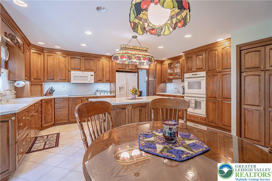1434 Colgate Drive Bethlehem, PA 18017 - Photo 18 of 37 a kitchen with stainless steel appliances granite countertop a refrigerator a stove a sink dishwasher with a dining table and chairs