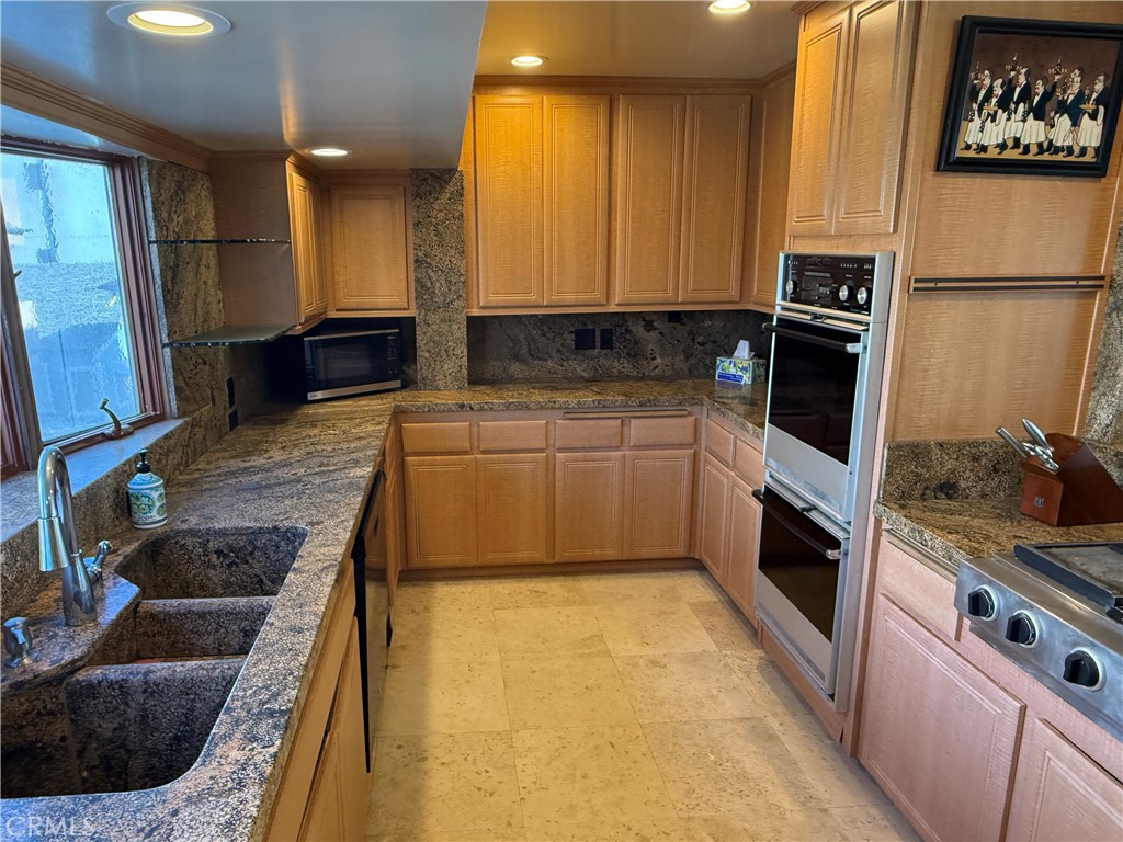 87 A Surfside Avenue Surfside, CA 90743 - Photo 13 of 14 a kitchen with stainless steel appliances a stove a sink and a refrigerator