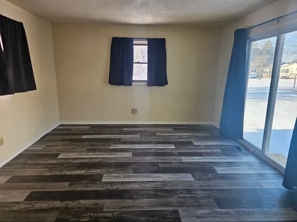 a view of wooden floor and windows in a room