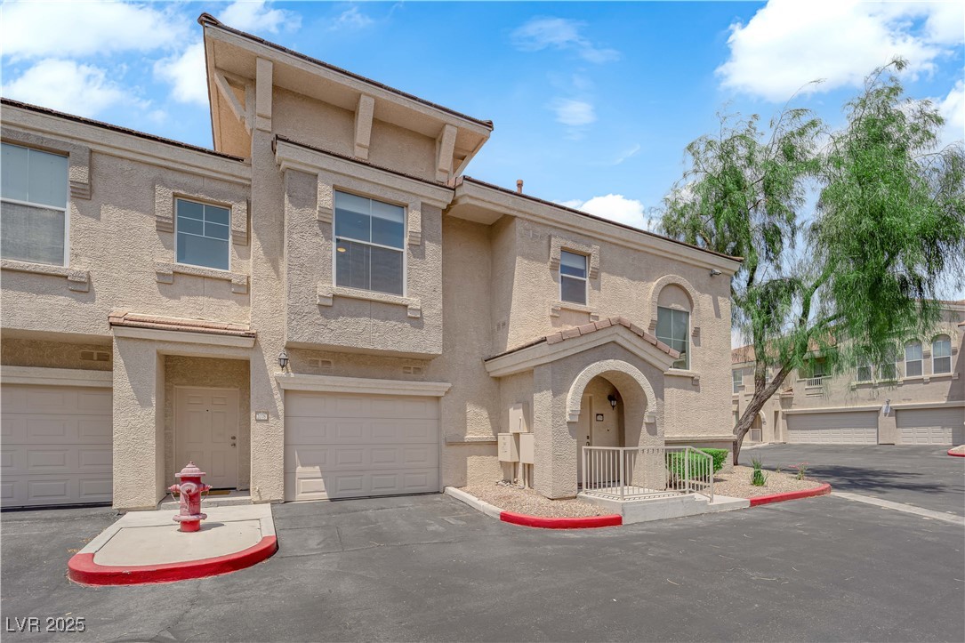 10550 West Alexander Road, Unit 2079 Las Vegas, NV 89129 - Photo 39 of 40 Townhome / multi-family property featuring stucco siding and a garage