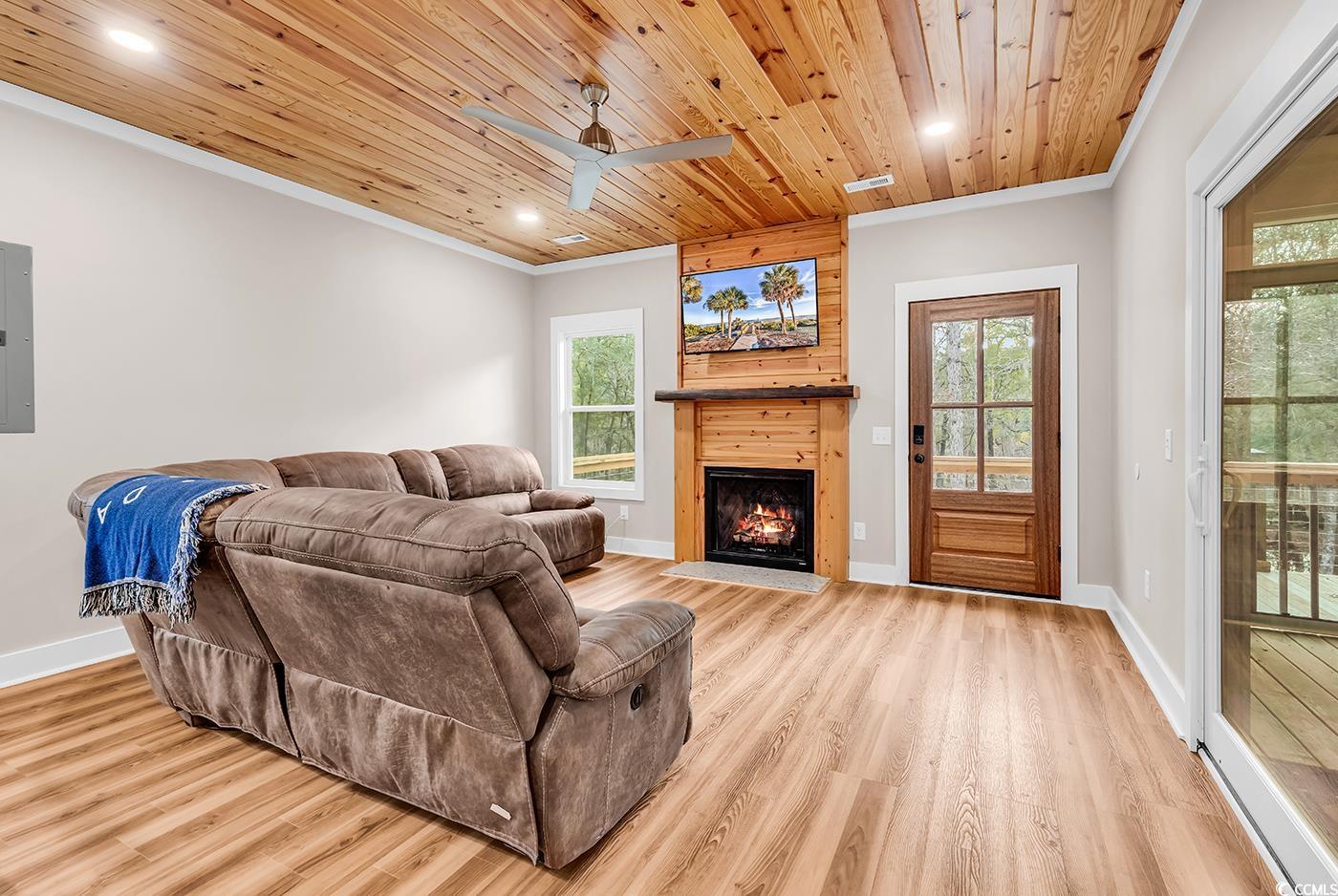 32 Old Place Kingstree, SC 29556 - Photo 14 of 40 Living area with wood ceiling, a warm lit fireplace, recessed lighting, light wood-style flooring, and electric panel