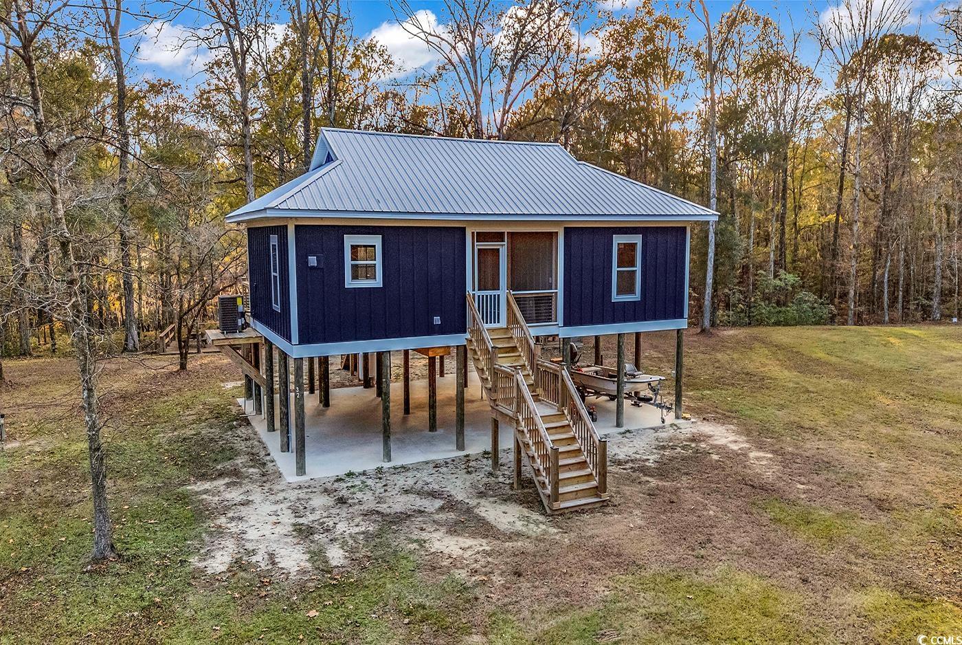 32 Old Place Kingstree, SC 29556 - Photo 31 of 40 Back of property featuring stairway, a metal roof, and a yard