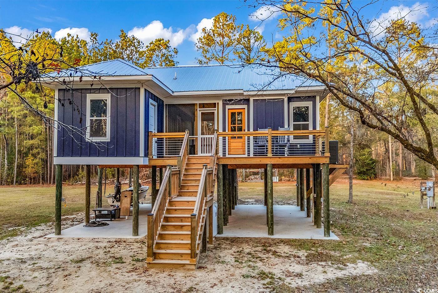 32 Old Place Kingstree, SC 29556 - Photo 34 of 40 View of front facade featuring stairway, a wooden deck, a metal roof, a patio area, and a carport