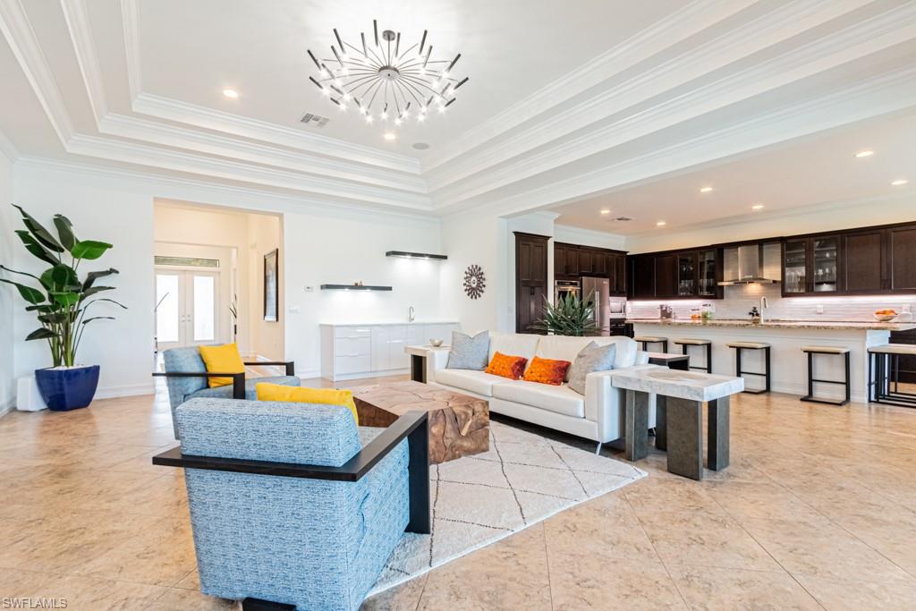 9380 Glenforest Drive Naples, FL 34120 - Photo 15 of 49 a living room with lots of furniture and a chandelier