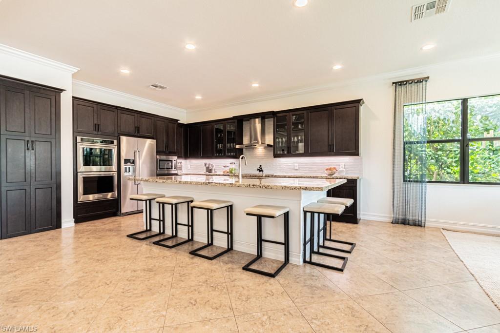 9380 Glenforest Drive Naples, FL 34120 - Photo 17 of 49 a kitchen with stainless steel appliances kitchen island granite countertop a sink and cabinets